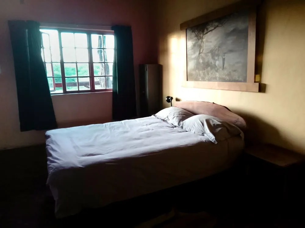 Dormitorio doble con vistas al exterior, donde el silencio del bush y la luz natural crean un ambiente de descanso único.